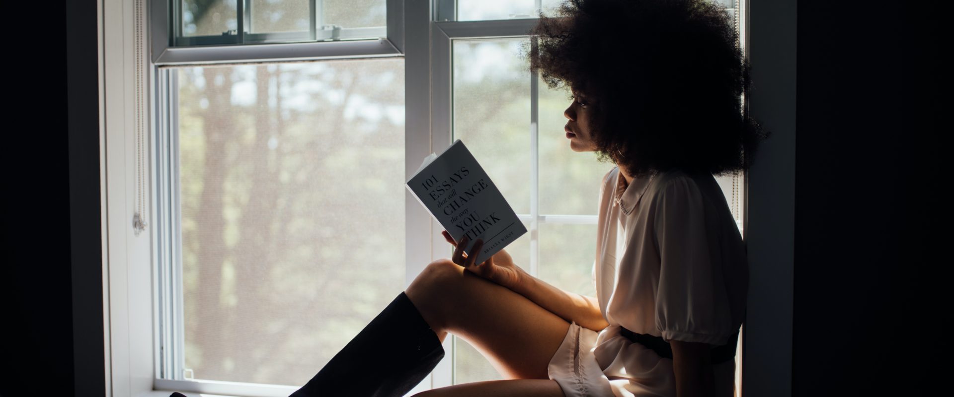 a woman with long natural hair reading a book