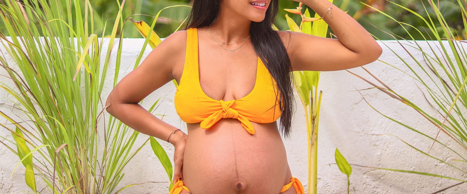 a woman with a pregnant belly in a bikini